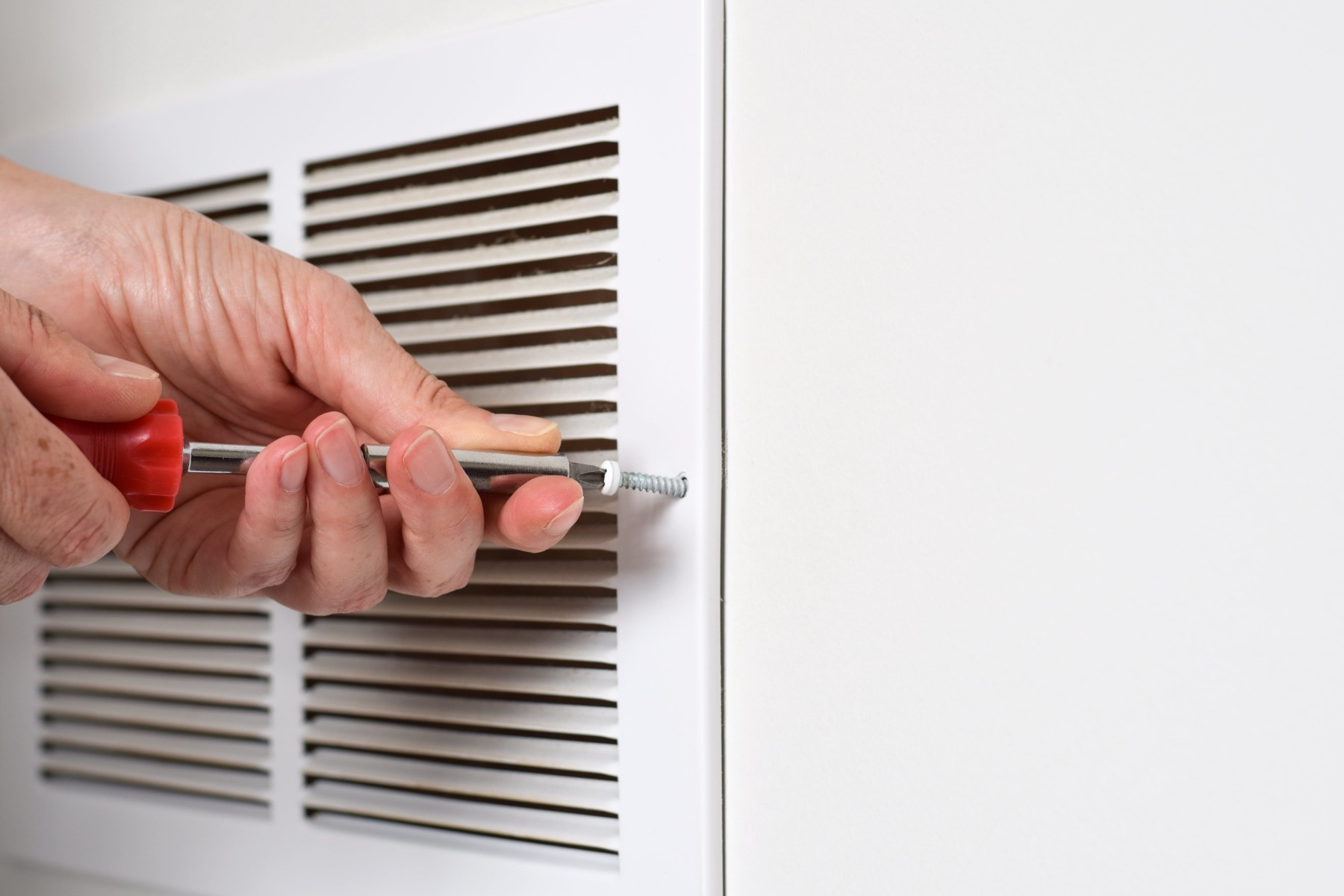 schroevendraaier en ventilatierooster muur